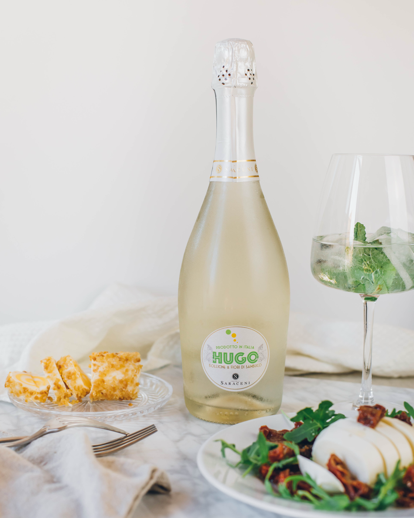 Hugo Spritz — pale sparkling sweet wine with bright green reflections, 750ml, Saraceni Wines (marble table lifestyle image)